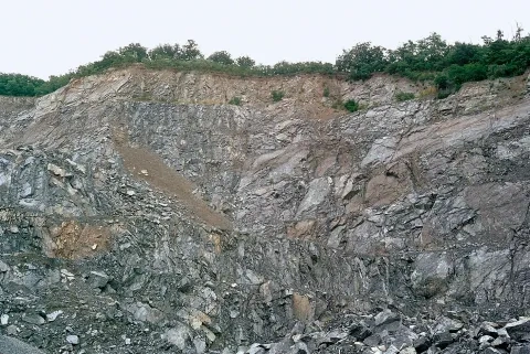 Telesá hlbinných hornín (červené granity) prenikajúce do kryštalických bridlíc, Brno, Česko 