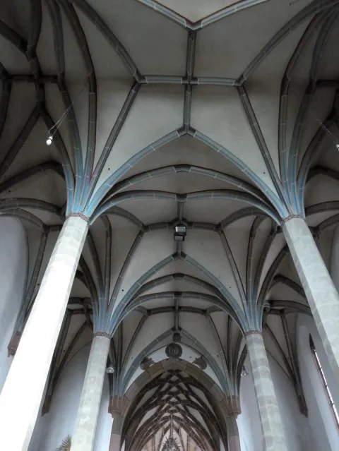 Gotická rebrová hviezdicová klenba v hale Kostola sv. Petra z Alkantary v Okoličnom, v pozadí sieťová klenba presbytéria,  Li