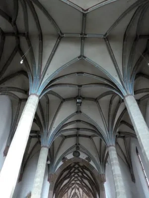 Gotická rebrová hviezdicová klenba v hale Kostola sv. Petra z Alkantary v Okoličnom, v pozadí sieťová klenba presbytéria,  Li